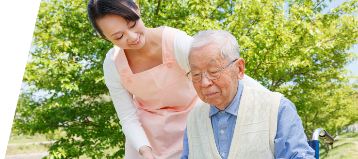 Elderly man in wheelchair with his caregiver