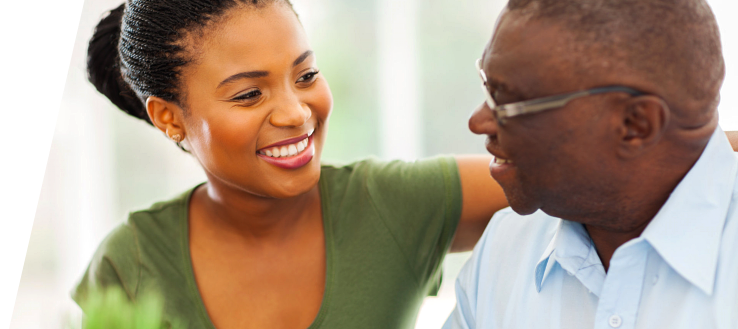 Elderly man in wheelchair with his caregiver smiling