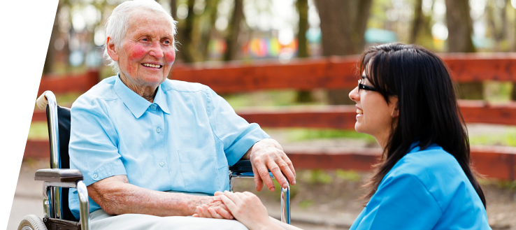 Elderly woman in wheelchair with her caregiver